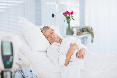 happy patient lying on her bed in hospital