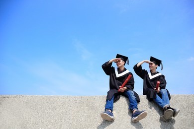 two happy graduates student look sky , asian