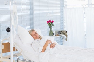 happy patient lying on her bed in hospital