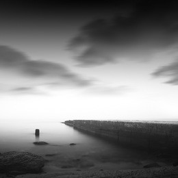 beautiful minimalist black and white seascape with sea wave cutter and milk water. shot taken in daytime with long exposure
