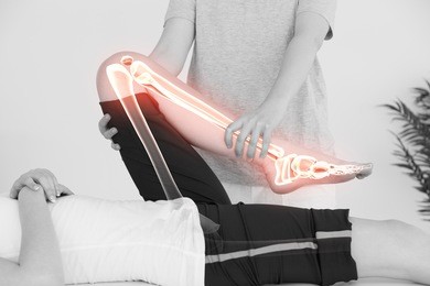 digital composite of highlighted bones of woman at physiotherapist