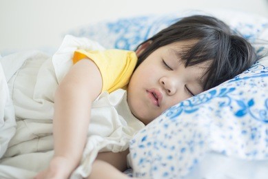 cute asian baby sleeping on bed