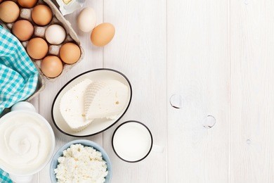 dairy products on wooden table. sour cream, milk, cheese, eggs, yogurt and butter. top view with copy space
