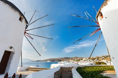 white greek windmills overlooking little venice popular tourist destination at traditional village on mykonos island, greece, europe