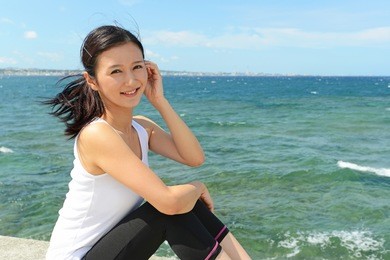 young woman who exercises by the sea wall