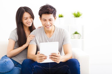 young couple on sofa with tablet computer