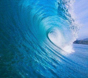 large blue surfing wave breaks in the ocean