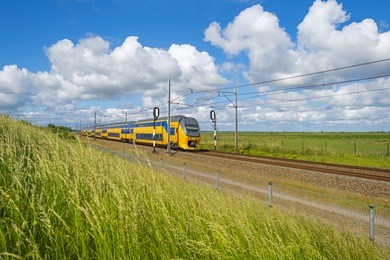 electric train driving through nature in spring 