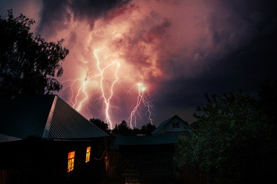 thunderbolt over the house and dark stormy sky on the background