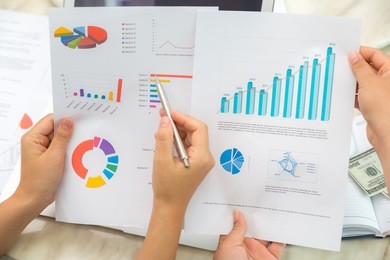 group of business people pointing at business document during meeting