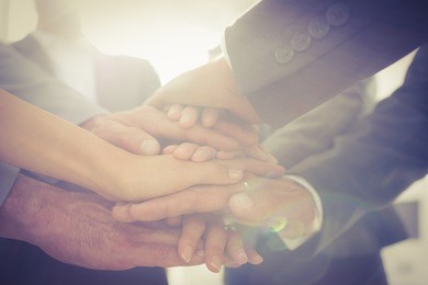 business team standing hands together in the office