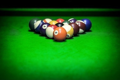 billiard balls. a vintage style photo from a billiard balls in a pool table. noise added for a film effect