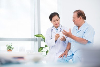 doctor giving pills to her patient in hospital