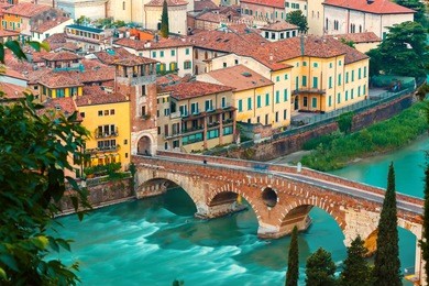 ancient roman bridge ponte pietra and the river adige at evening, view from piazzale castel san pietro, verona, italy