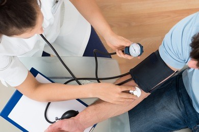 close-up of female doctor checking blood pressure of male patient