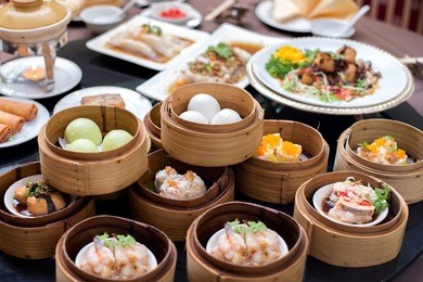 yumcha,the arrangment of various dim sum in bamboo steamer with chinese bun , pao , bao zi , steamed dumpling , shumai on table in chinese restaurant