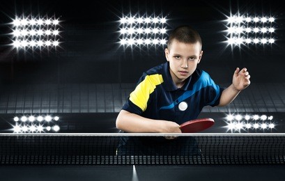 portrait of kid playing tennis on black background