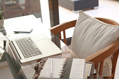 still life of a home office room with a laptop computer and a smart phone, house interior. working from home technology in a home work desk, indoors. high technology lifestyle workplace.