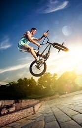 bmx bicycle rider tricking on the highlights