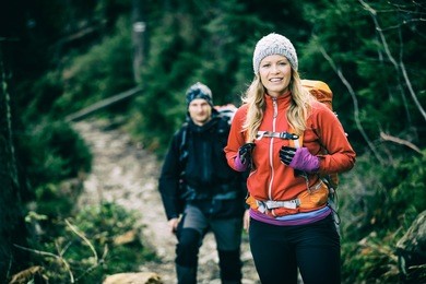 man and woman happy couple hikers trekking in green autumn forest and mountains. young people walking on trail with backpacks, healthy lifestyle adventure, camping on hiking trip, vintage photo style.