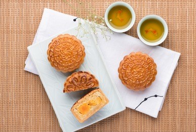 famous moon cake with assorted nuts and egg yolk. mooncake and tea,chinese mid autumn festival food.