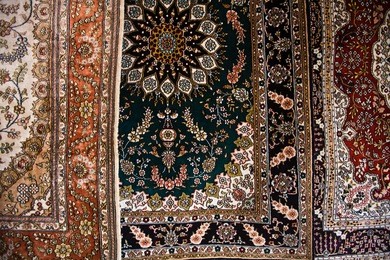 close up image of 3 ornate persian style carpets made in kashgar china