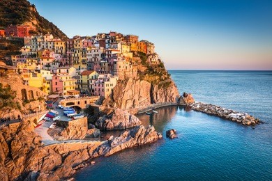 manarola, liguria, italy. the wonderful manarola village as you can see it from the mountain above. quiet sky and peaceful sea, during sunset.