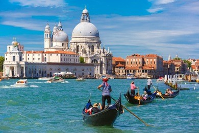 picturesque view of gondolas on canal grande with basilica di santa maria della salute in the background, venice, italy. selective focus on gondolier