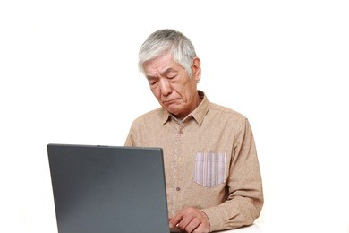 senior japanese man using computer looking confused