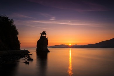 sunset from stanley park, vancouver, bc, with a silhouette of siwash rock
