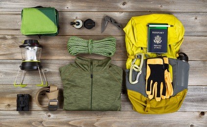 high angled view of organized hiking gear for climbing placed on rustic wooden boards. 