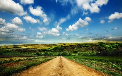 landscape with dirt road in the mountains under cloudy sky 