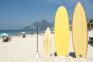 surfboards and stand up paddle boards line up on the beach at arpoador, ipanema, rio de janeiro brazil