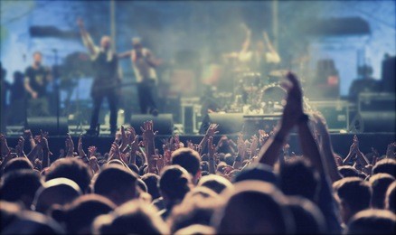 crowd at concert - cheering crowd in front of bright colorful stage lights