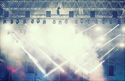 crowd at concert - cheering crowd in front of bright colorful stage lights