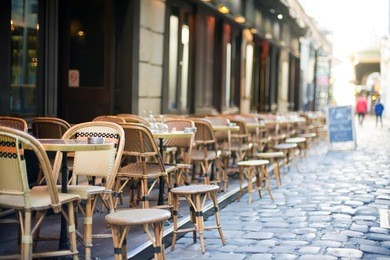 empty tables in between dining hours along a paris cobblestone alley