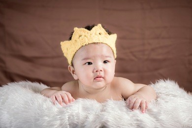 asian baby boy lying on bed
