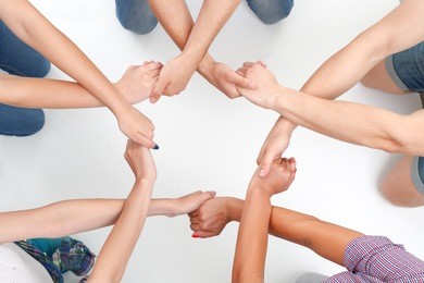 team work. group of young friendly people making ring of hands on white isolated background.