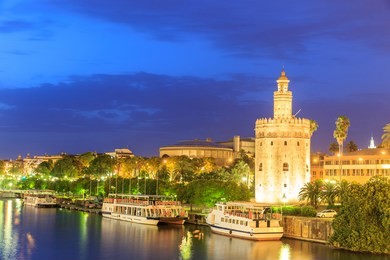 golden tower (torre del oro) of seville, andalusia, spain over river guadalquivir at sunset