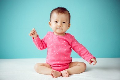 asian baby girl wearing pink clothing on the blue background in winter season, baby healthy and winter concept