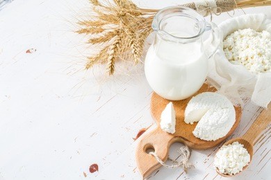 fresh dairy products (milk, cottage cheese), wheat, white wood background, top view