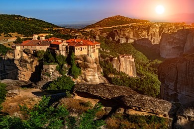 sunset over meteora mountain monasteries, greece