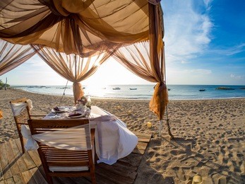 romantic dinner setting on the beach at sunset