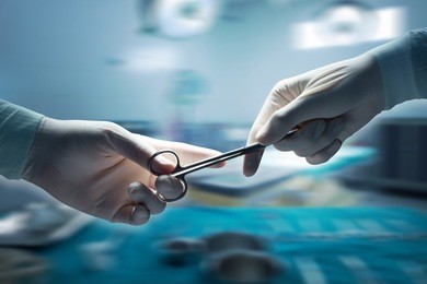 healthcare and medical concept , close-up of surgeons hands holding surgical scissors and passing surgical equipment , motion blur background.