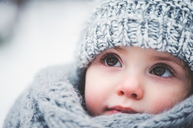 winter close up outdoor portrait of adorable dreamy baby girl in grey knitted hat and scarf