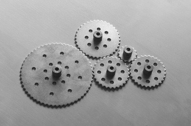 five metallic gears on black and white