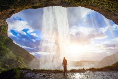 incredible waterfall in iceland, silhouette of man enjoying amazing view of nature