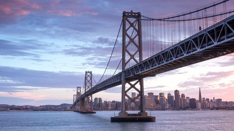 sunset over san francisco-oakland bay bridge and san francisco skyline. yerba buena island, san francisco, california, usa.