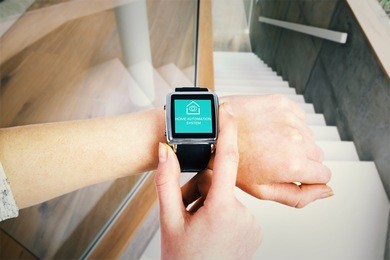 woman using smartwatch against white staircase in a modern home