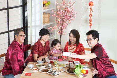 celebrating chinese new year, reunion dinner. happy asian chinese multi generation family with red cheongsam selfie while dining at home.